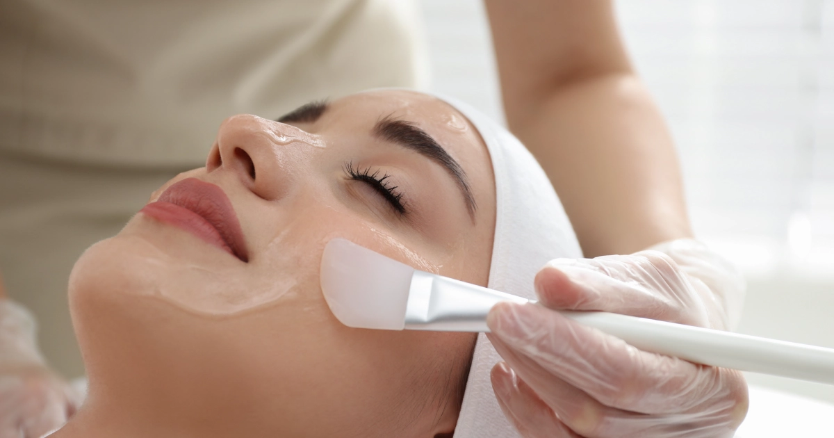 An aesthetician applying a chemical peel to a woman's face in Panama City Beach, FL